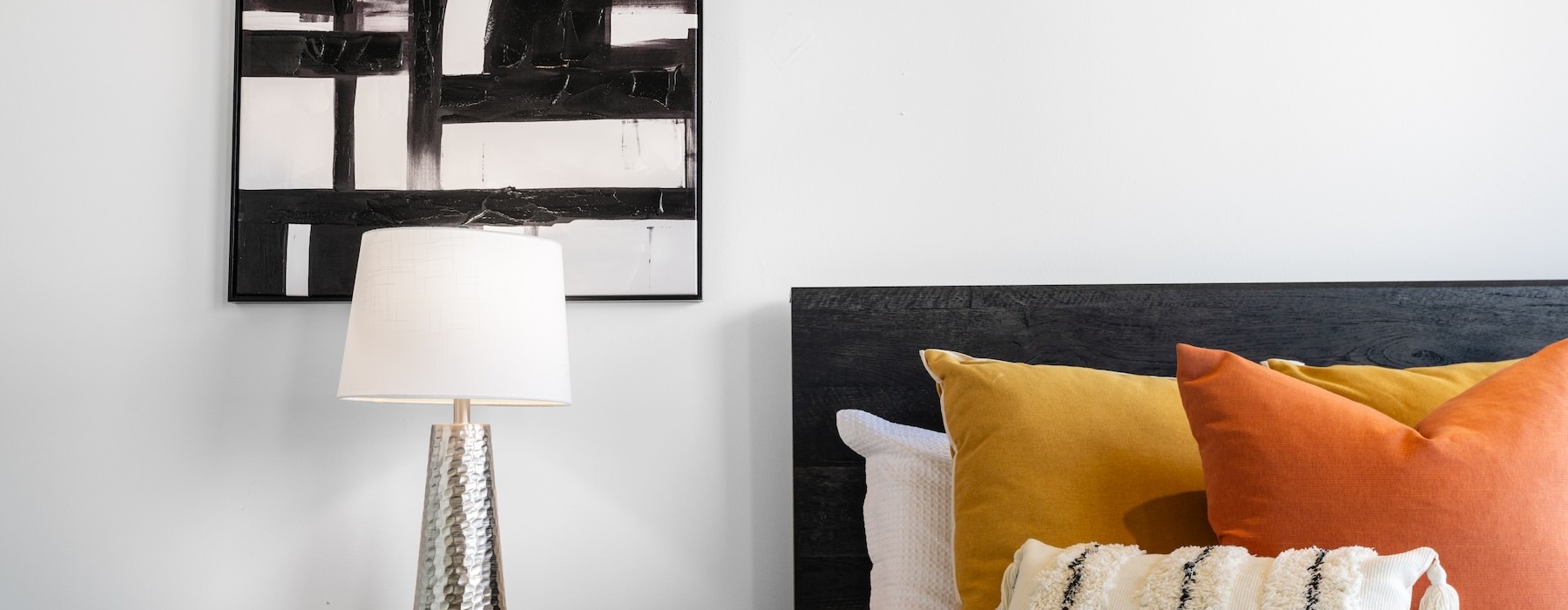 a bedroom with a bed and a lamp on a table
