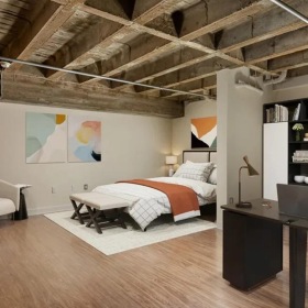 a room with a bed, desk and a bookcase